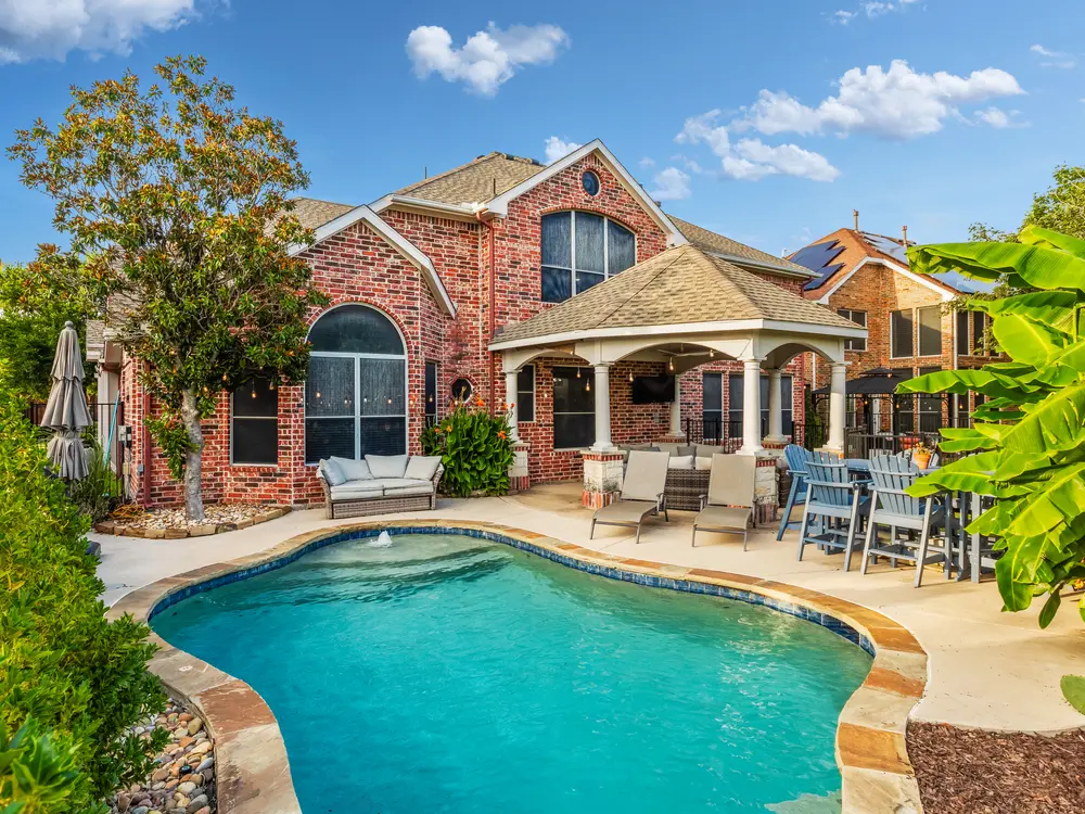 Brick estate exterior with pool and loggia
