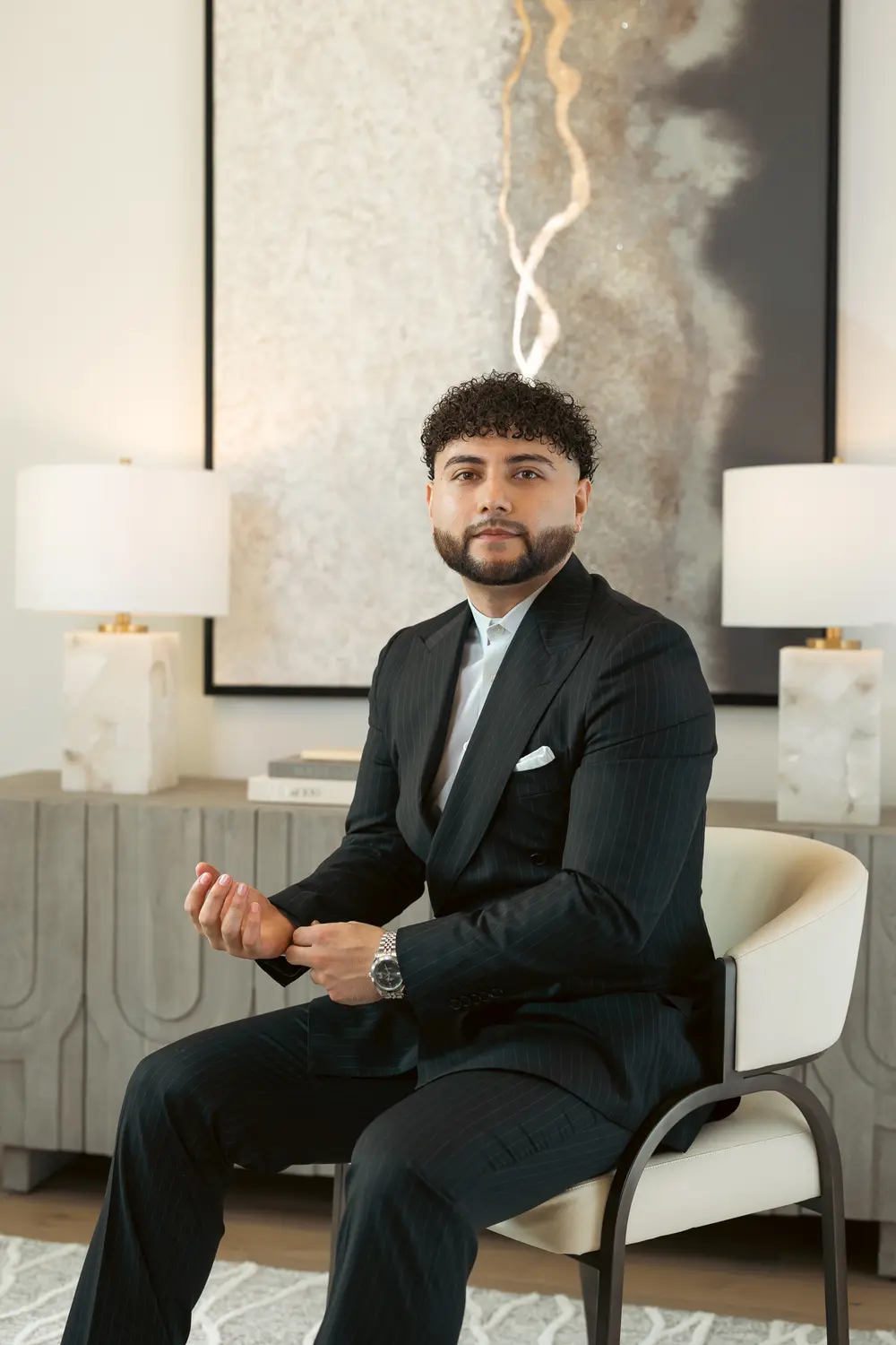 Agent in a pinstripe suit seated in a modern lounge